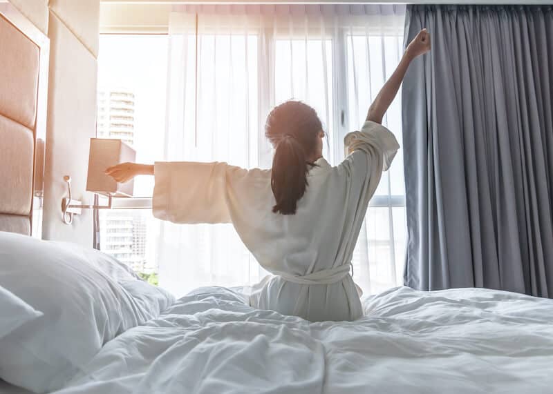 quick-guide-to-sleep-coaching Image of woman waking up refreshed after working with a sleep coach for adults