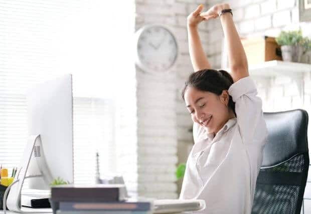 Woman stretching at her desk during work